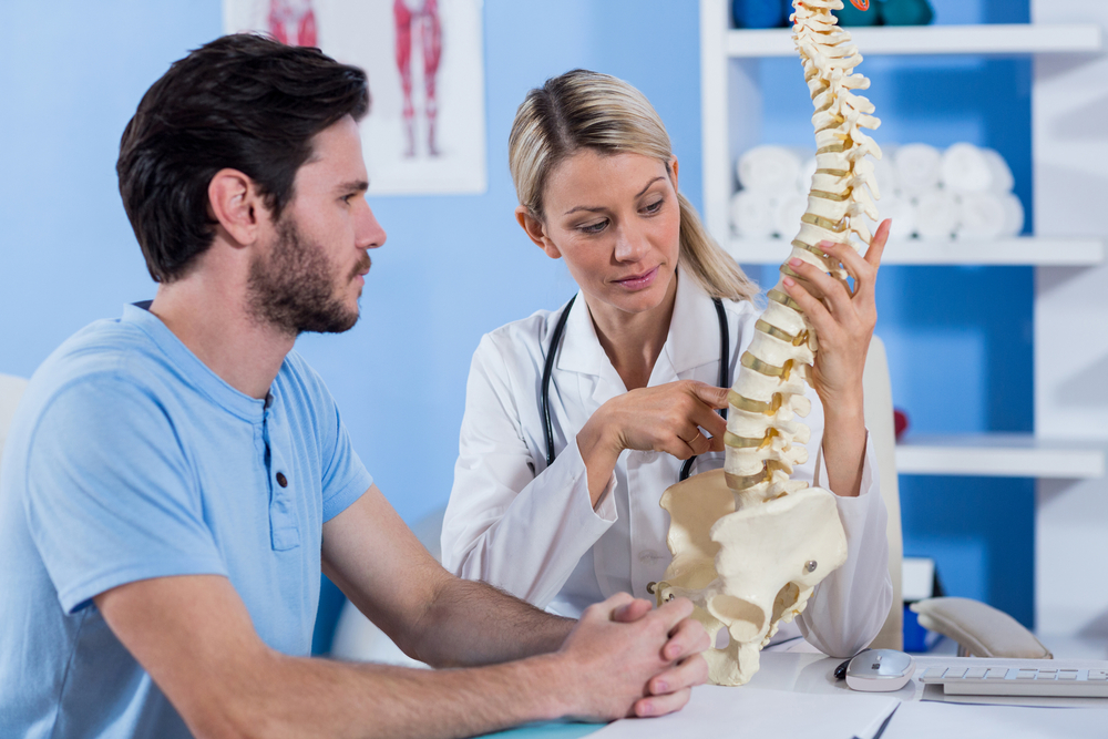 Physiotherapist,Explaining,The,Spine,Model,To,Patient,In,The,Clinic